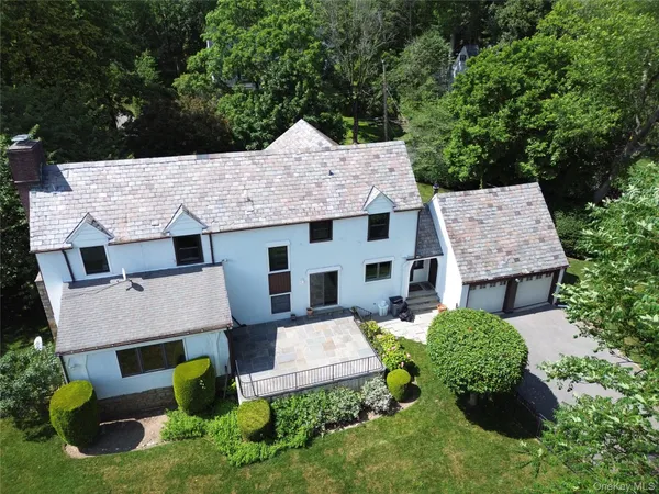 an aerial view of a house with a yard and large trees