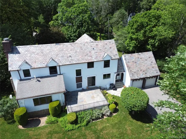 an aerial view of a house with a yard and large trees