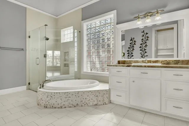 a bathroom with a granite countertop sink a mirror and a bathtub