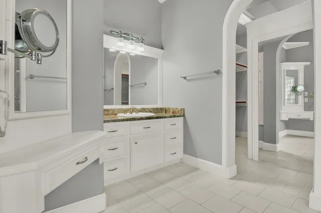 a spacious bathroom with a granite countertop sink and a mirror