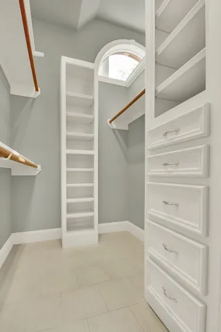 a view of walk in closet with empty racks