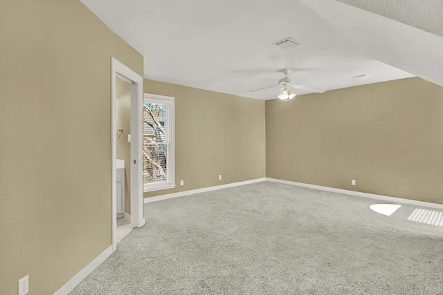 an empty room with closet and a chandelier fan