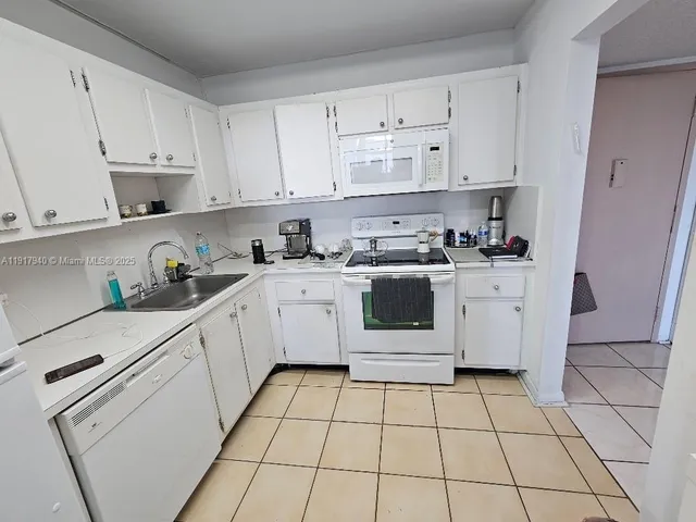 a kitchen with cabinets appliances a sink and a counter top