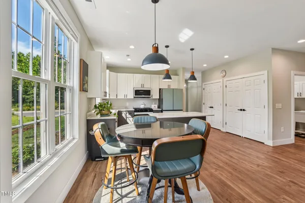 a kitchen with stainless steel appliances granite countertop a refrigerator a sink dishwasher a stove and a refrigerator with wooden floor