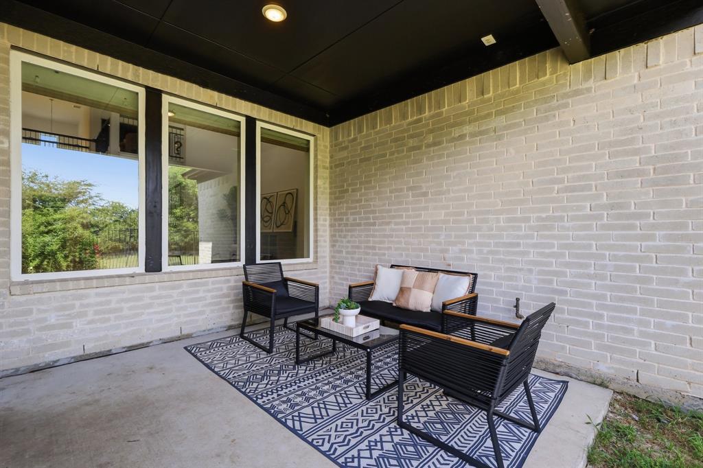 539 Farrell Lane Allen, TX 75013 - Photo 32 of 39 Covered patio featuring light-colored brick walls, a concrete slab, and a dark soffit with recessed lighting