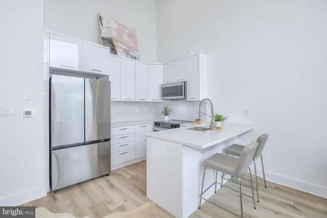 a kitchen with a refrigerator a stove a sink and a cabinets