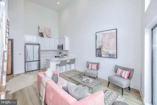 a living room with furniture and a dining table with kitchen view