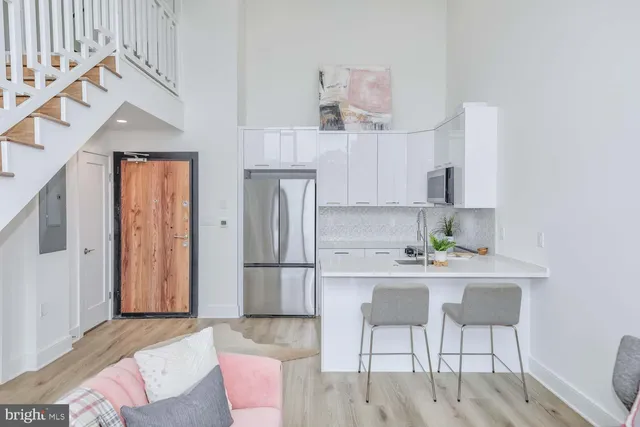 a kitchen with stainless steel appliances kitchen island granite countertop a refrigerator and a stove top oven