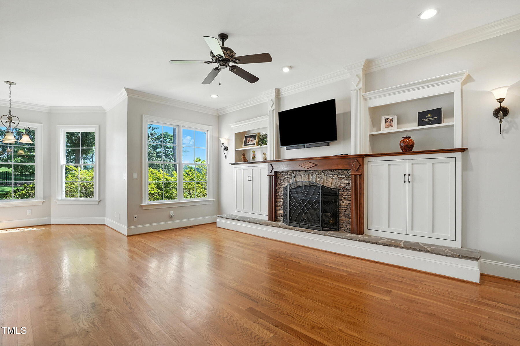 1605 Hunting Ridge Road Raleigh, NC 27615 - Photo 18 of 55 a view of an empty room with wooden floor fireplace and a window