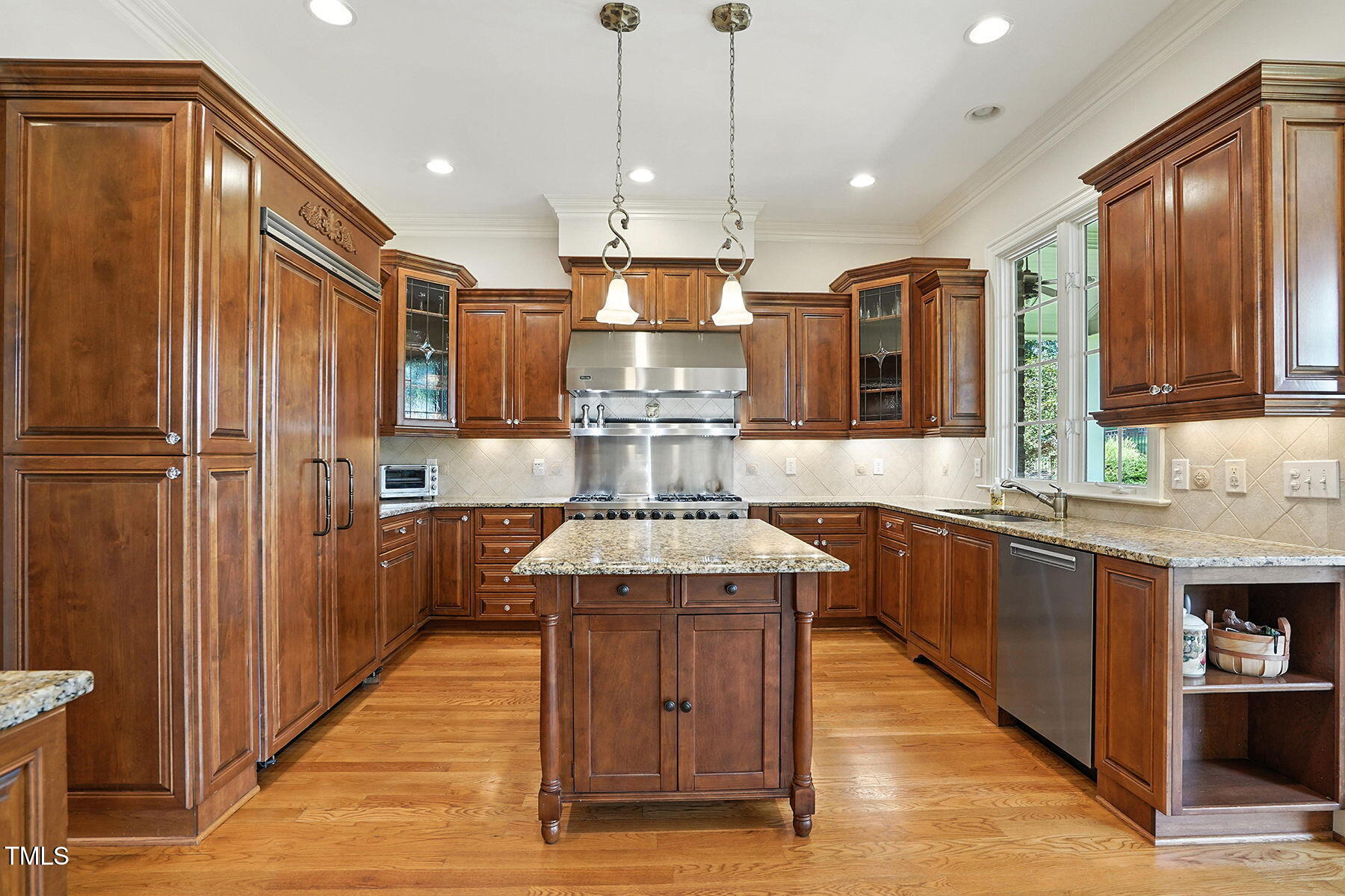 1605 Hunting Ridge Road Raleigh, NC 27615 - Photo 7 of 55 a kitchen with kitchen island granite countertop wooden cabinets and stainless steel appliances