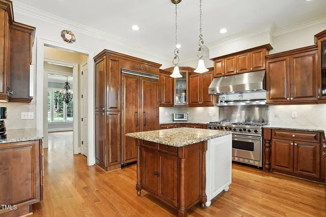 a kitchen with granite countertop kitchen island wooden cabinets and stainless steel appliances