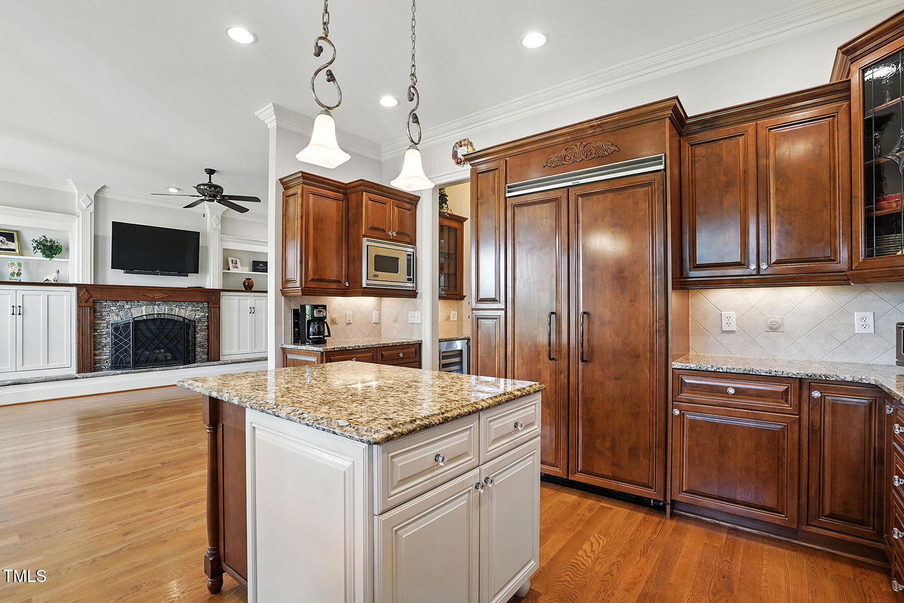 1605 Hunting Ridge Road Raleigh, NC 27615 - Photo 9 of 55 a kitchen with kitchen island granite countertop wooden cabinets and a refrigerator