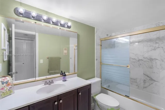 a bathroom with a sink a toilet a mirror and shower