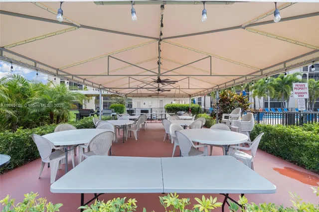 a view of a patio with a table and chairs under an umbrella