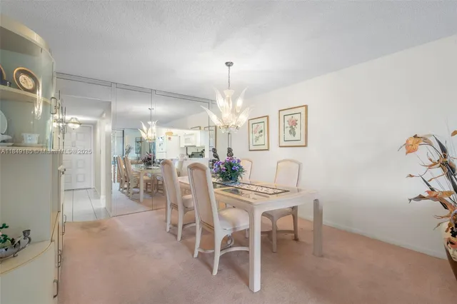 a view of a dining room with furniture and a chandelier