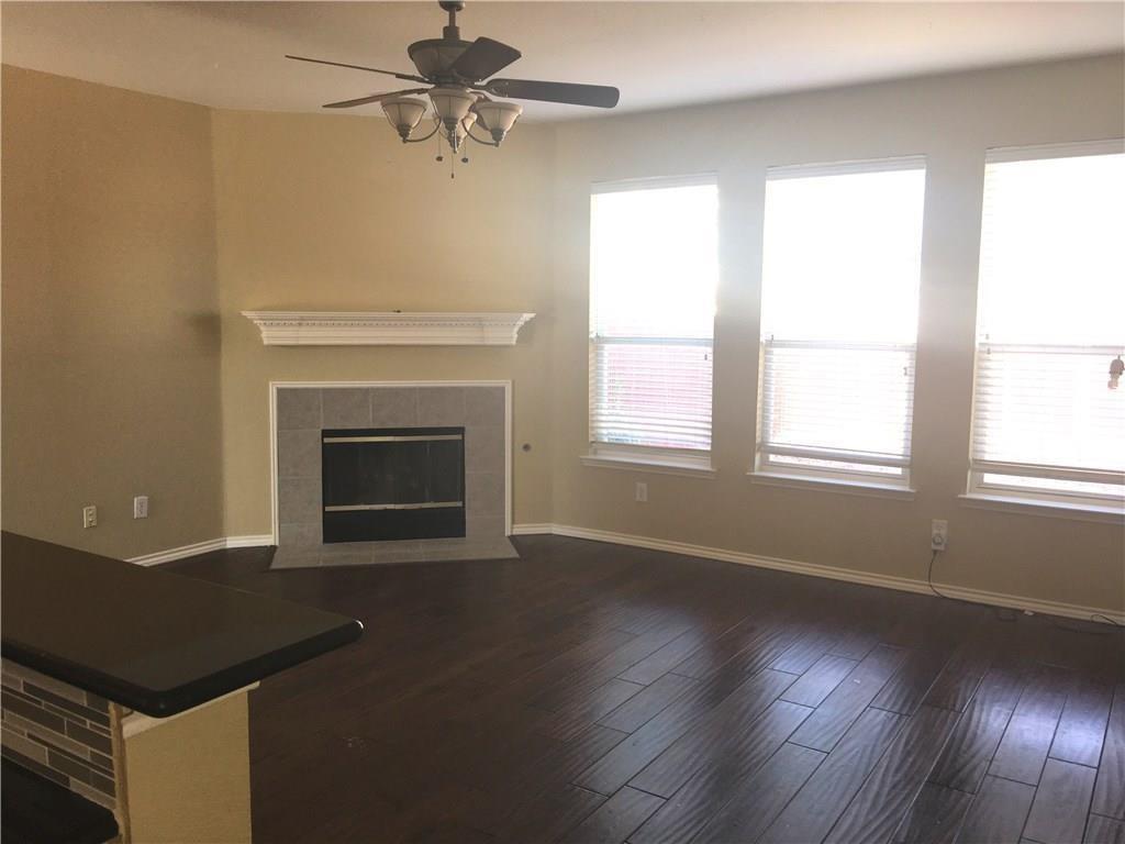 4433 Riptide Lane Plano, TX 75024 - Photo 5 of 12 Living area featuring rich wood-finish flooring and a fireplace with a tiled surround and decorative mantel