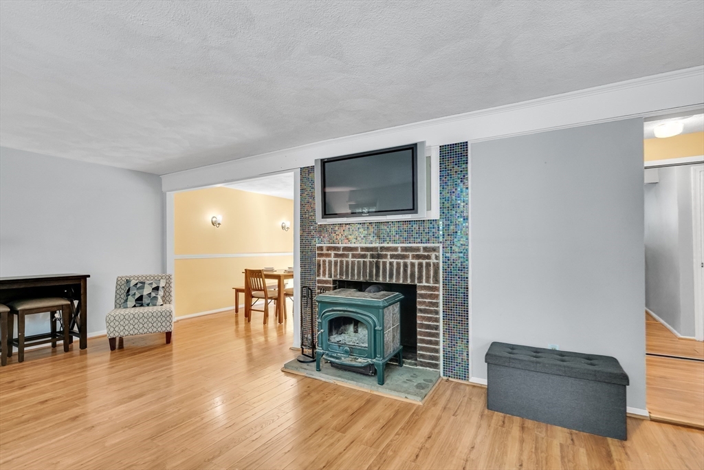 58 MacIntosh Lane, Unit 58 Boxborough, MA 01719 - Photo 11 of 23 a living room with furniture and a fireplace