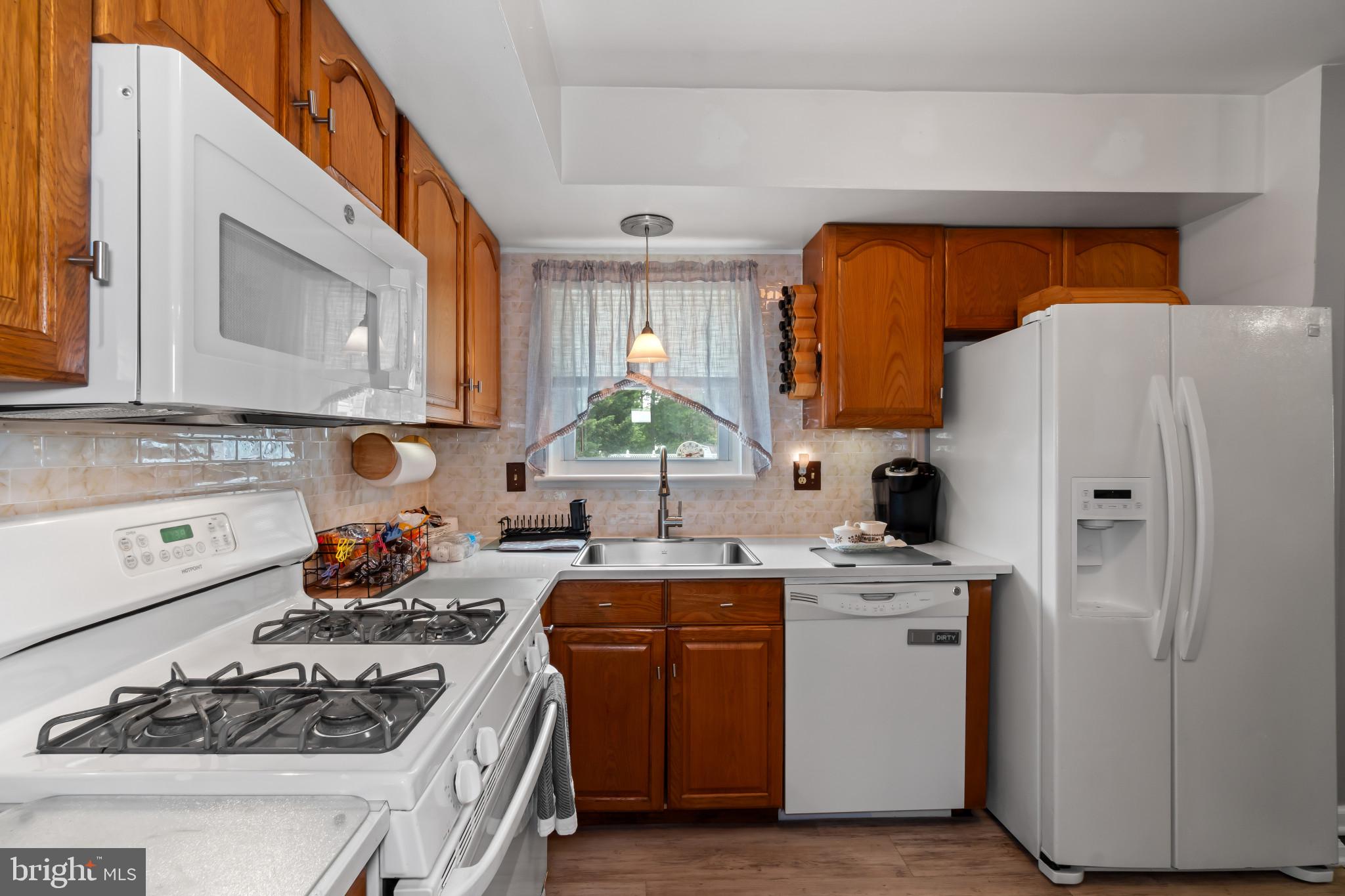 407 Bowleys Quarters Road Baltimore, MD 21220 - Photo 9 of 38 a kitchen with a stove a sink and a refrigerator