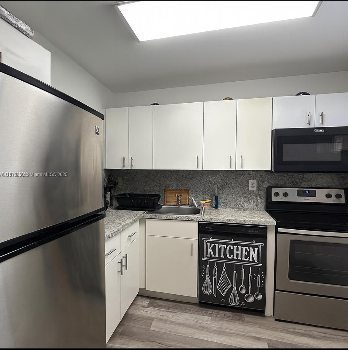 11301 Southwest 200th Street, Unit 306A Miami, FL 33157 - Photo 4 of 10 a kitchen with stainless steel appliances granite countertop a stove and a refrigerator