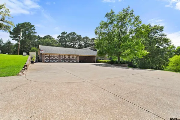 a front view of a house with a garden and trees