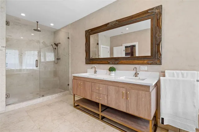 a bathroom with a double vanity sink a mirror and a bathtub