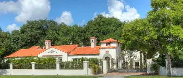 a front view of a house with a yard and potted plants