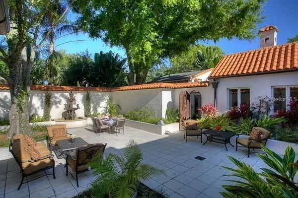a view of a patio with couches table and chairs and potted plants