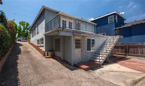 a front view of a house with glass windows and stairs