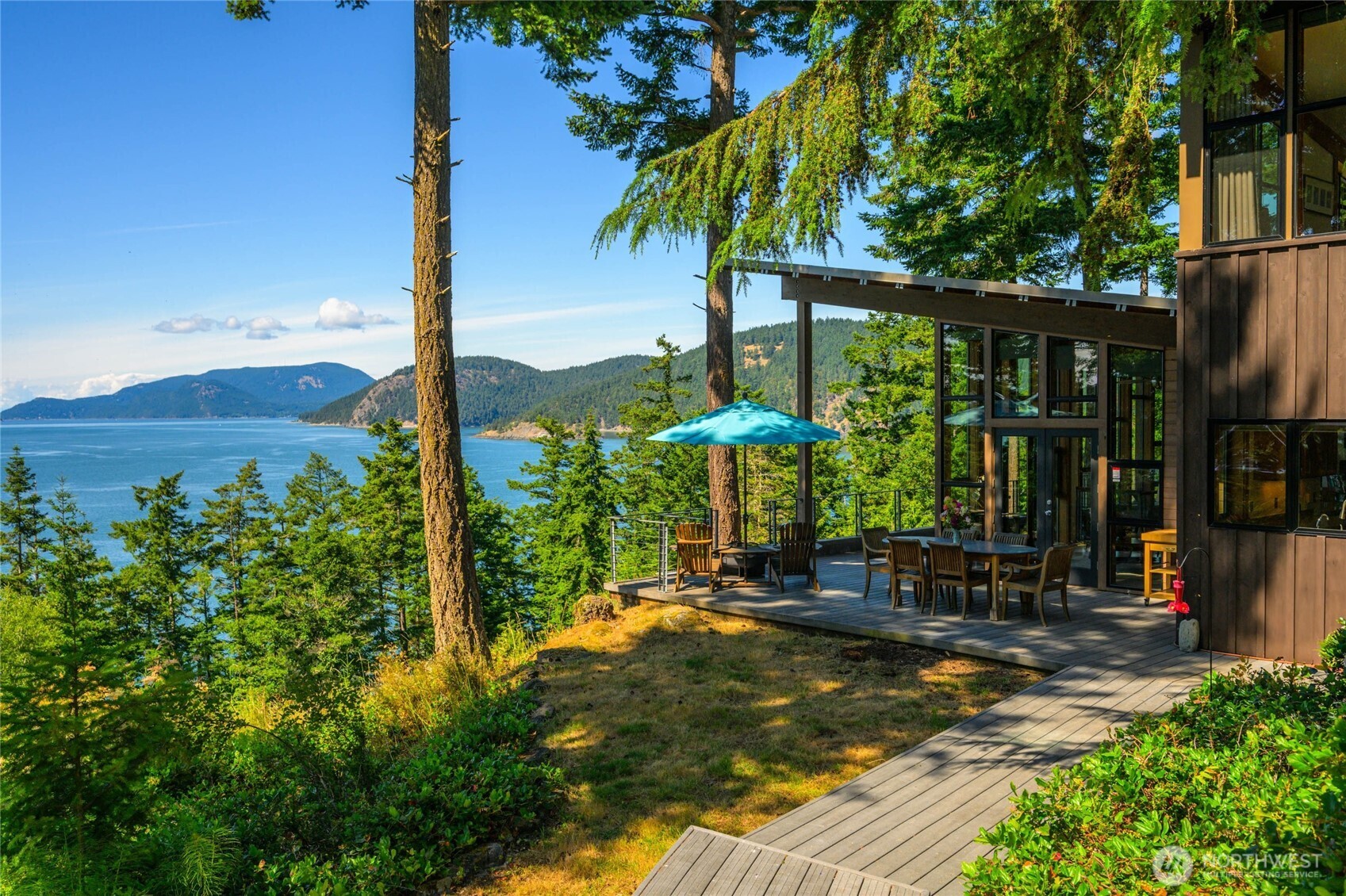 405 Northwest Thatcher Pass Road Decatur Island, WA 98221 - Photo 35 of 40 a view of a patio with table and chairs potted plants and palm tree
