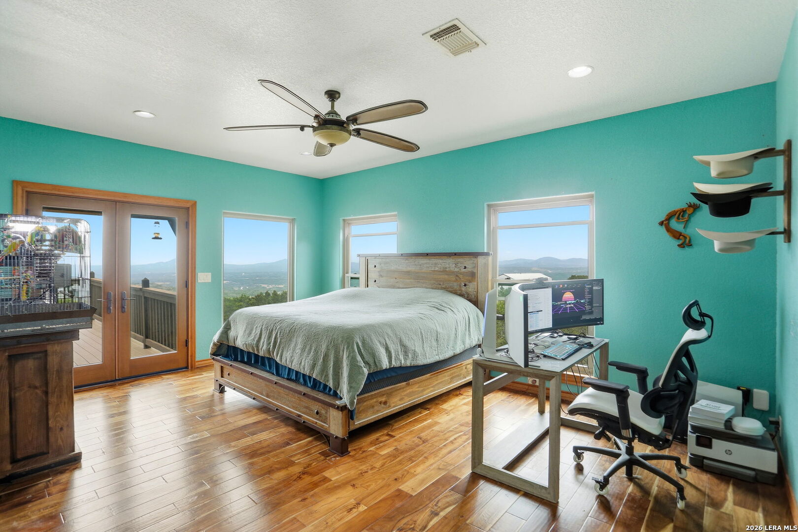 232 Doe Run Road Pipe Creek, TX 78063 - Photo 12 of 40 a spacious bedroom with a bed and a chandelier