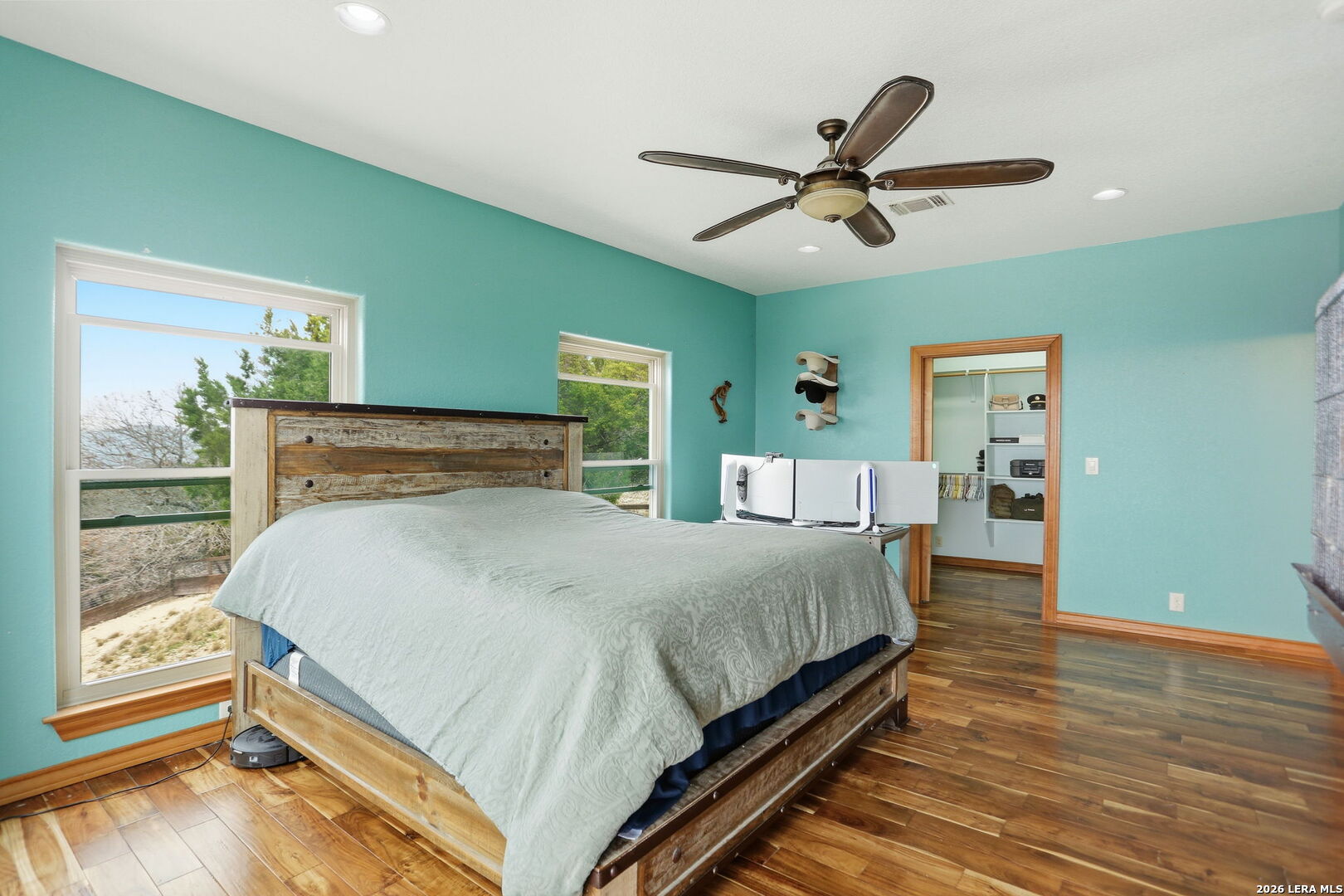 232 Doe Run Road Pipe Creek, TX 78063 - Photo 14 of 40 a bedroom with a large bed and a chandelier