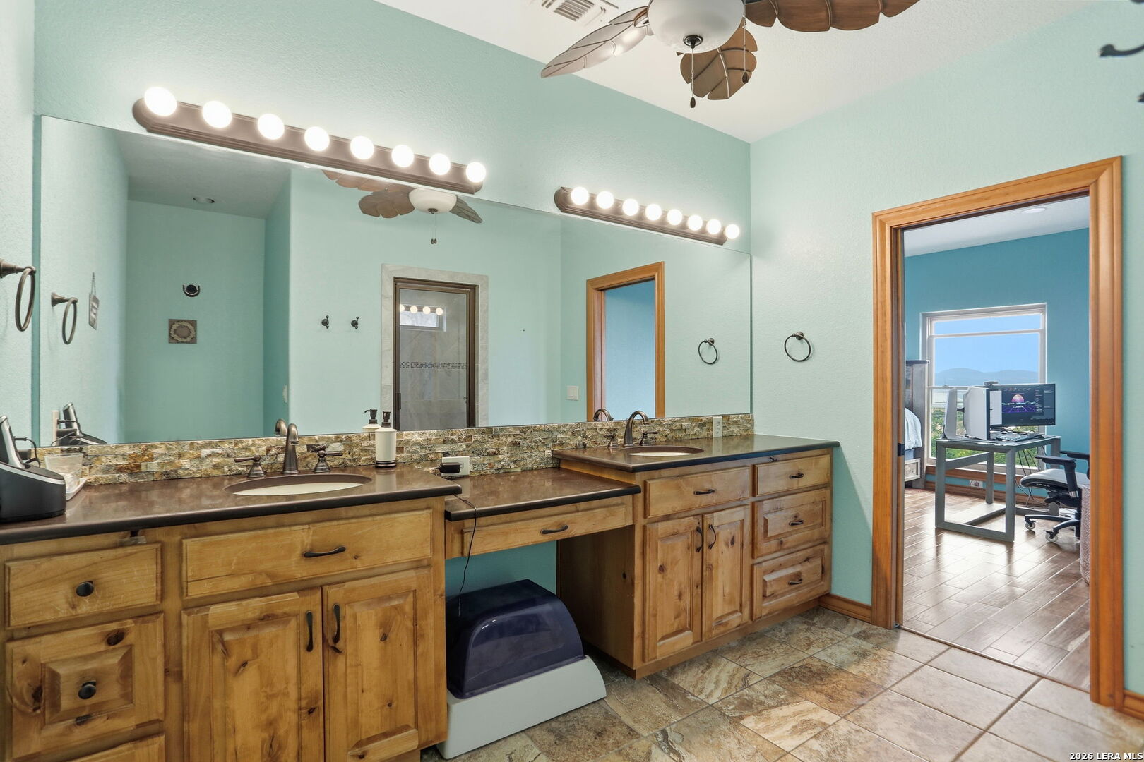 232 Doe Run Road Pipe Creek, TX 78063 - Photo 17 of 40 a spacious bathroom with a granite countertop sink and a mirror