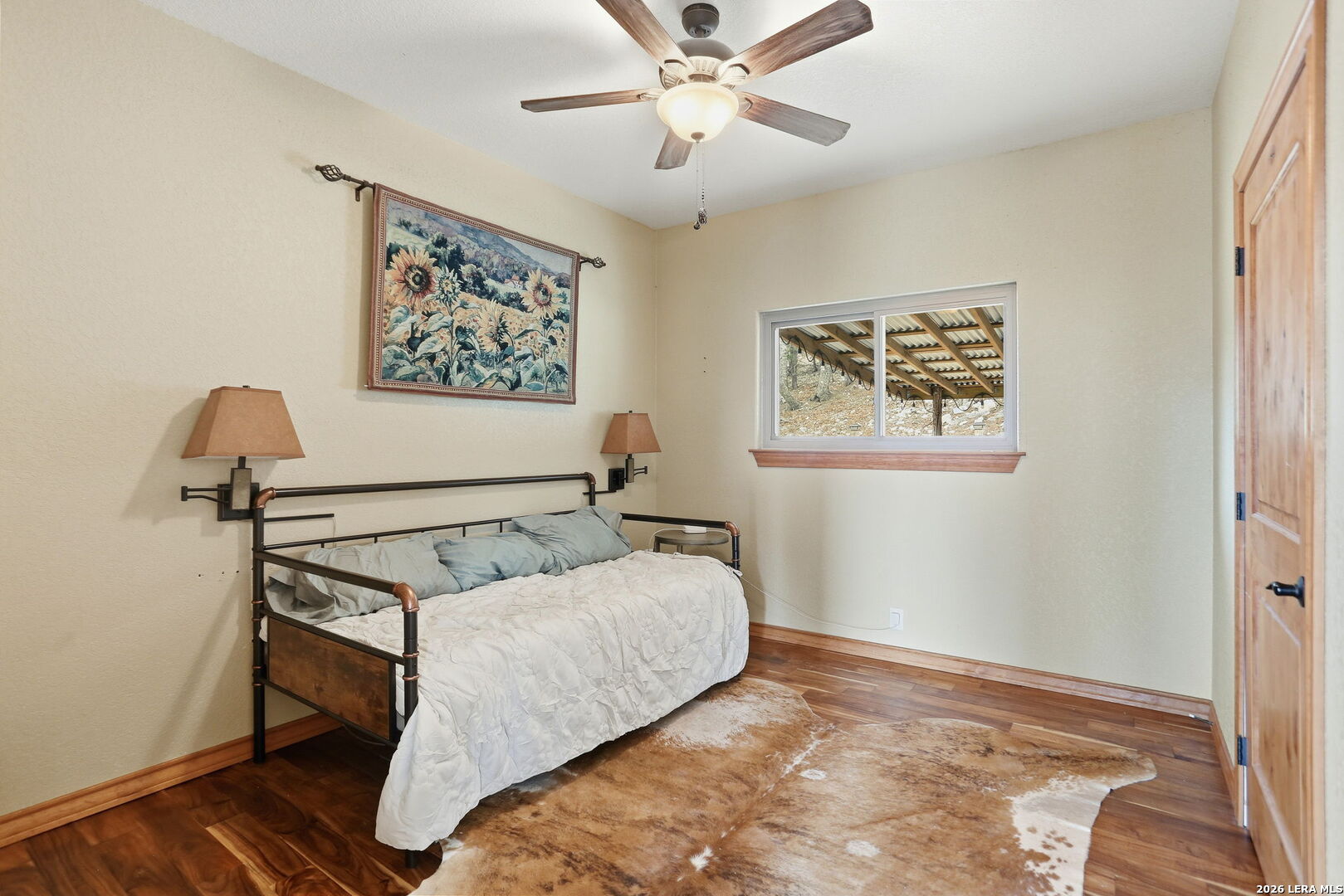 232 Doe Run Road Pipe Creek, TX 78063 - Photo 19 of 40 a bedroom with a bed and a chandelier