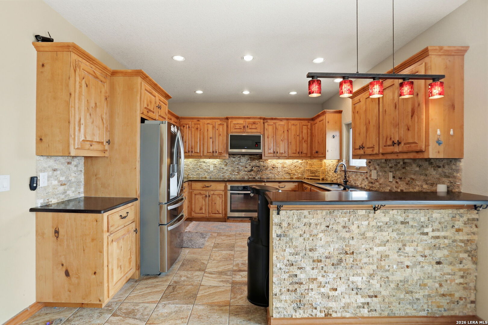 232 Doe Run Road Pipe Creek, TX 78063 - Photo 9 of 40 a kitchen with stainless steel appliances granite countertop a sink a stove and a refrigerator