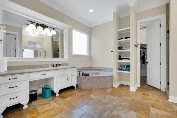 a spacious bathroom with a granite countertop sink mirror and bathtub
