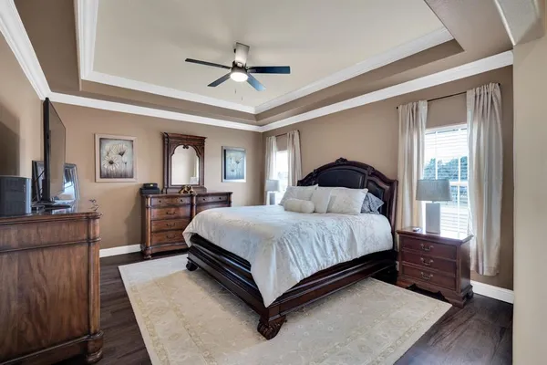 a large bedroom with a bed and wooden floor