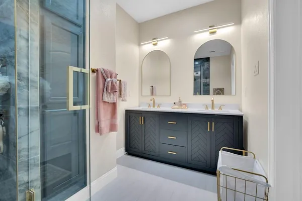 a bathroom with a double vanity sink mirror and shower