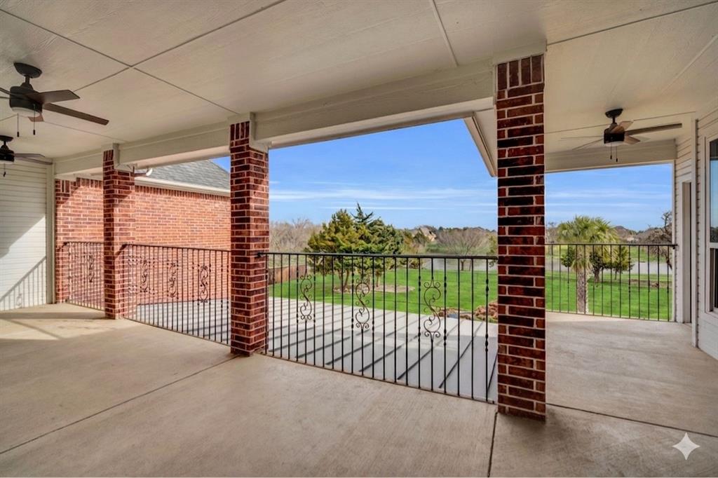 3530 Pleasantville Road Midlothian, TX 76065 - Photo 39 of 40 Expansive covered patio featuring a concrete surface, decorative wrought iron railing, brick columns, and ceiling fans