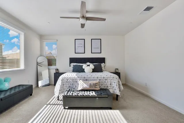a living room with furniture a ceiling fan and a window