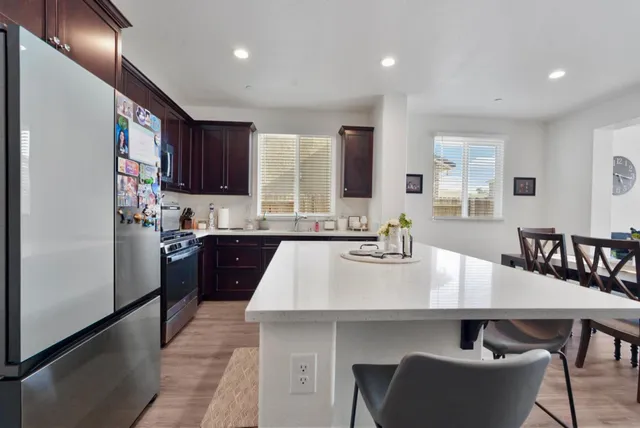 a kitchen with refrigerator a sink and chairs