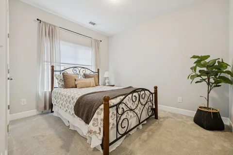 a bedroom with a bed and a potted plant