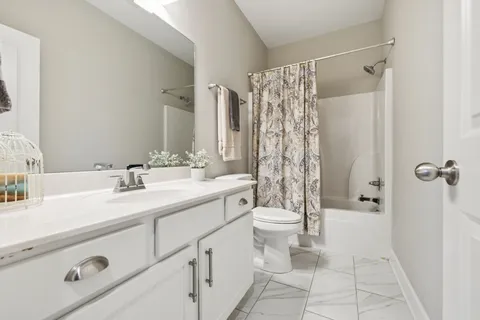 a bathroom with a double vanity sink toilet and shower