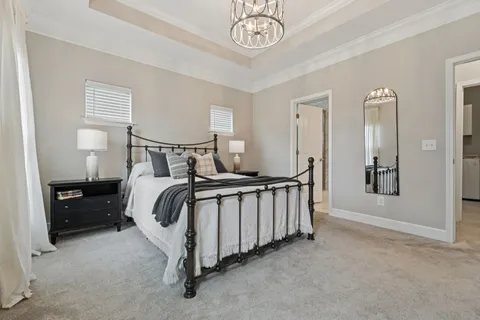 a bedroom with a bed and a chandelier