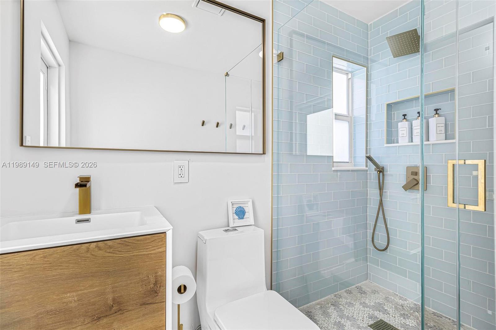18490 Southwest 83rd Place Cutler Bay, FL 33157 - Photo 22 of 84 a bathroom with a granite countertop sink a toilet and shower