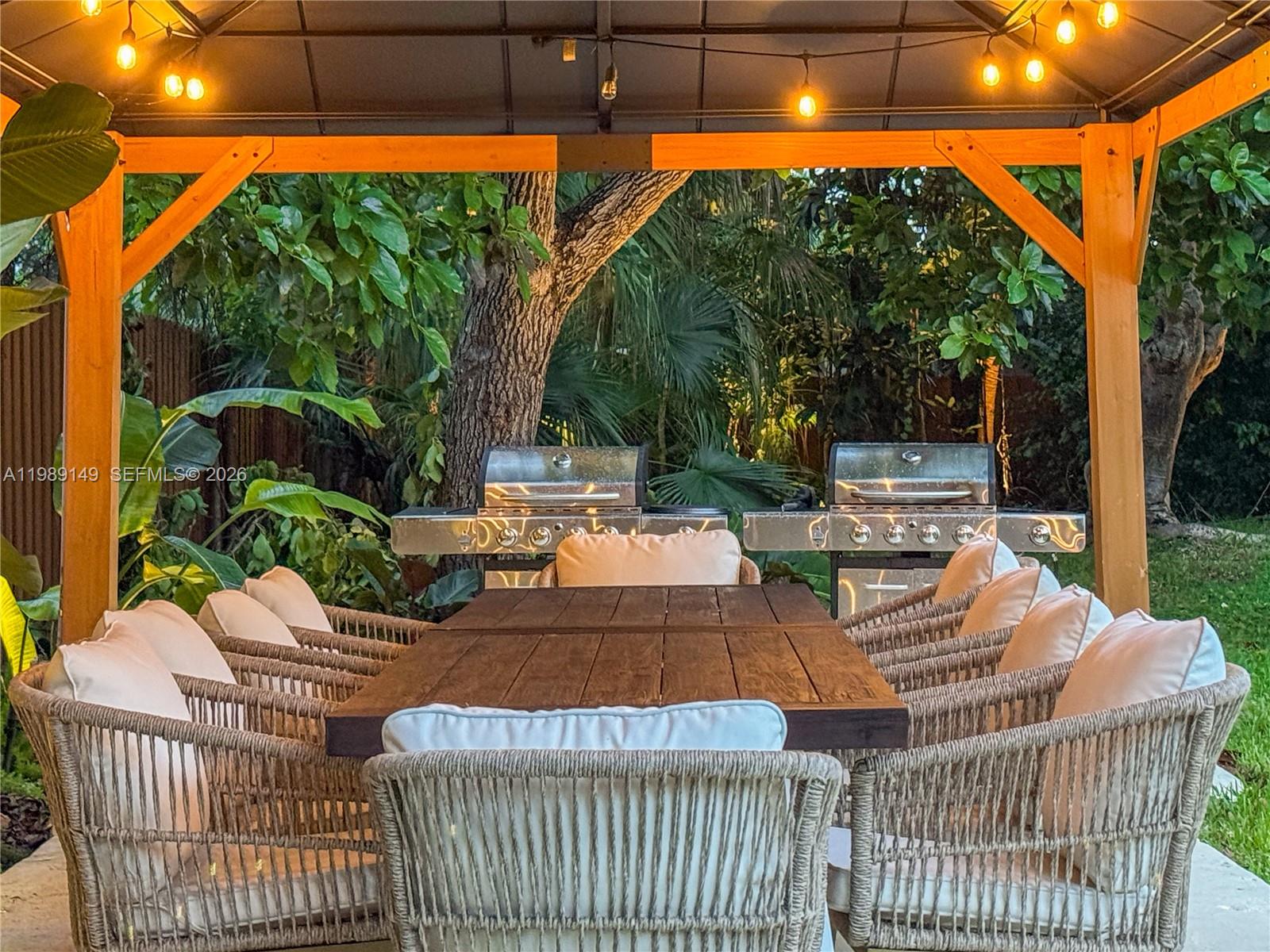 18490 Southwest 83rd Place Cutler Bay, FL 33157 - Photo 54 of 84 a view of a patio with dining table and chairs with a small yard