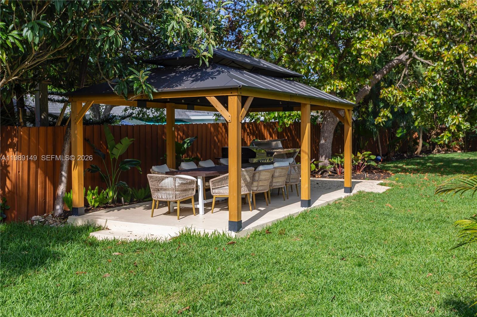 18490 Southwest 83rd Place Cutler Bay, FL 33157 - Photo 73 of 84 a view of a patio with table and chairs under an umbrella