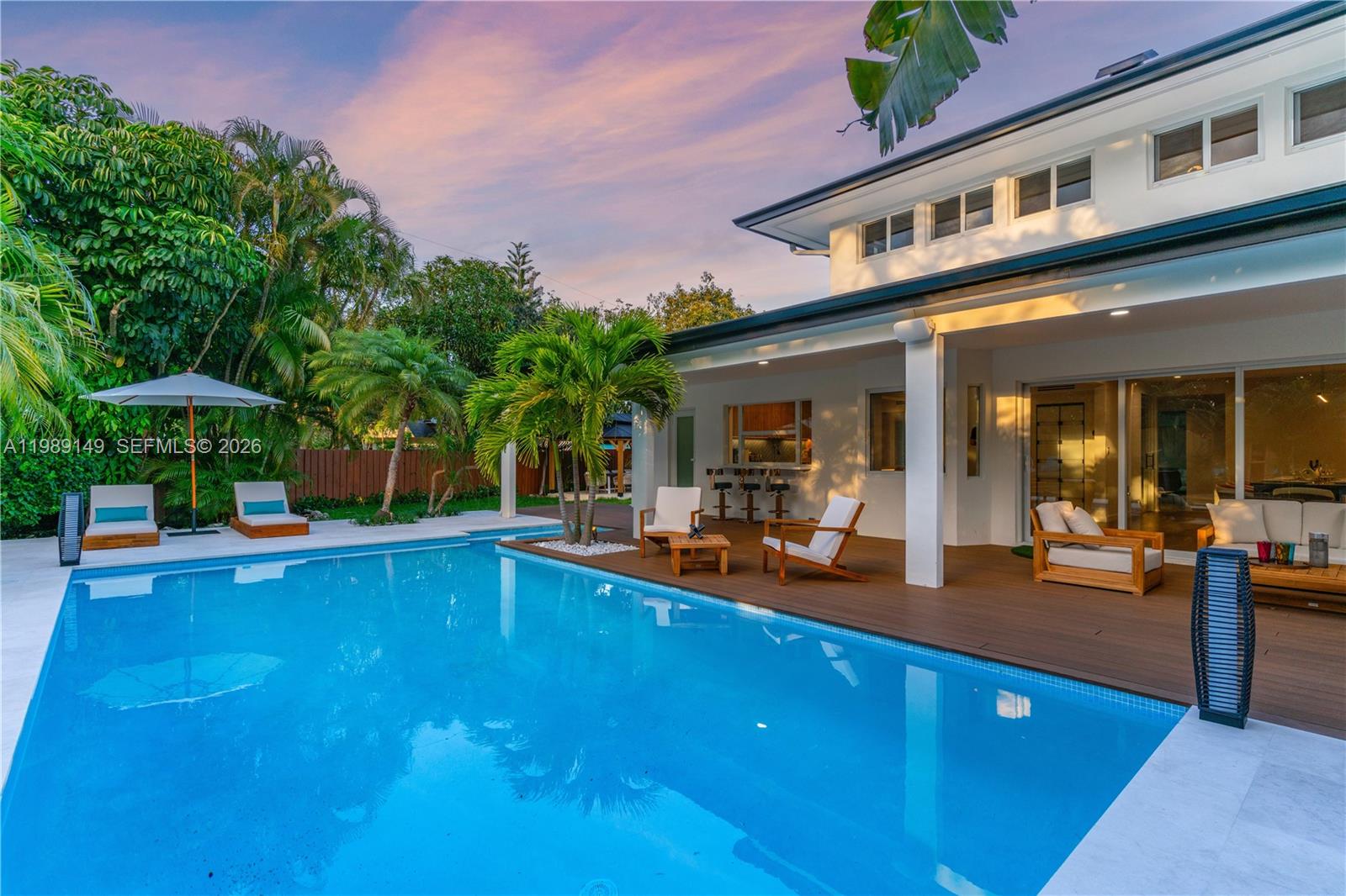 18490 Southwest 83rd Place Cutler Bay, FL 33157 - Photo 81 of 84 a view of a house with pool table and chairs under an umbrella