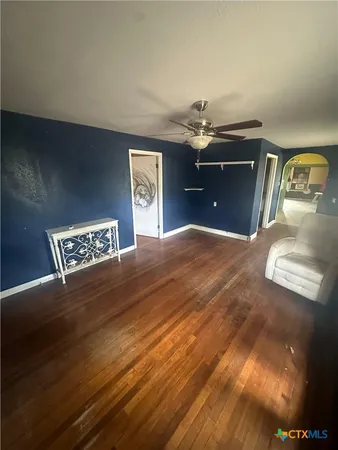en empty room with wooden floor and windows