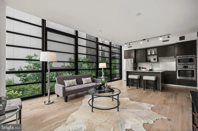 a living room with furniture a rug and kitchen view