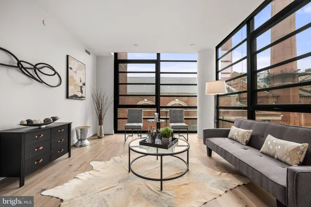 a living room with furniture a rug and a large window